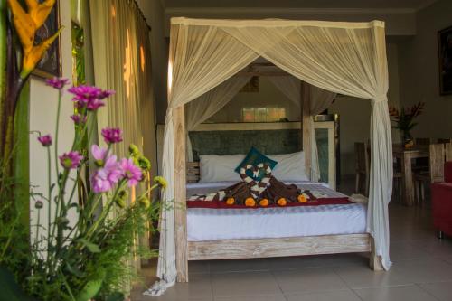 a bedroom with a canopy bed with fruit on it at Ratna Villa in Ubud