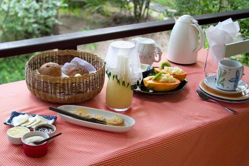 a table with food and a basket of fruit and juice at Pousada Vila Sereia in Ilha de Boipeba