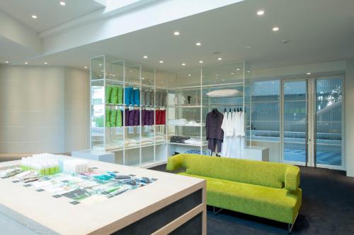 a clothing store with a yellow chair and a table at Agora Place Tokyo Asakusa in Tokyo