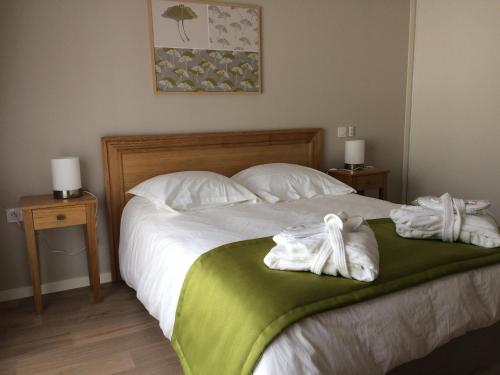 a bedroom with a bed with two towels on it at Domitys - Le Castel Du Val in Pérignat-lès-Sarliève