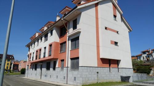 a white and orange building on the side of a street at Norte Sueve in Colunga