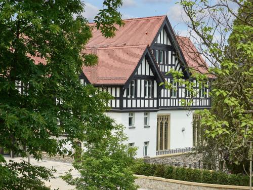 a black and white house with a red roof at Dorint Hotel Frankfurt/Oberursel in Oberursel