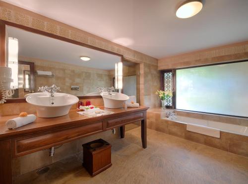 
a bathroom with two sinks, a toilet and a bathtub at The Ajit Bhawan - A Palace Resort in Jodhpur
