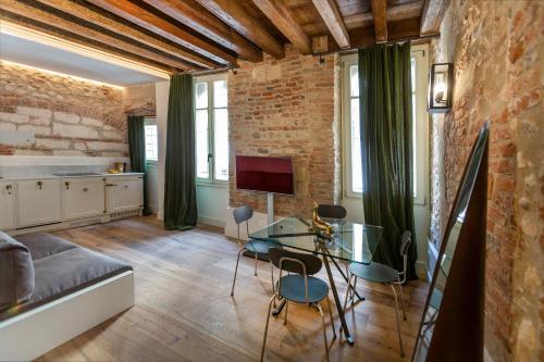a living room with a glass table and a brick wall at Residenza Palazzo Brenzoni in Verona