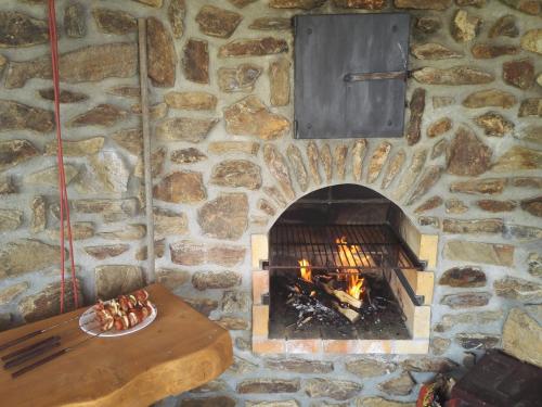 a stone wall with a fireplace with a table and a pizza at Javorník 88 in Javorník