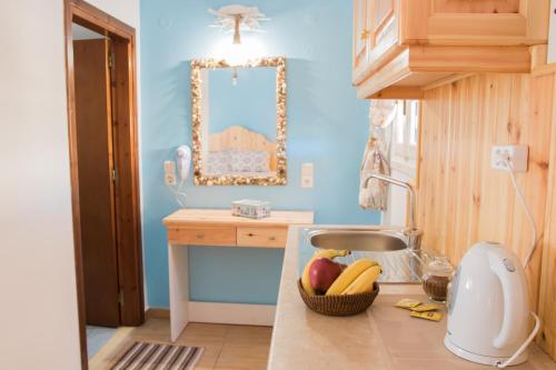 a kitchen with a counter with a sink and a mirror at Sofia´s rooms in Kyra Panagia