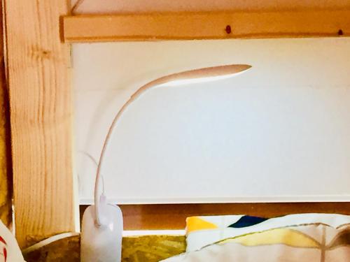 a lamp sitting on top of a bed next to a wall at Cloud Sharing Hotel Hakata 1 Guesthouse Dormitory in Fukuoka