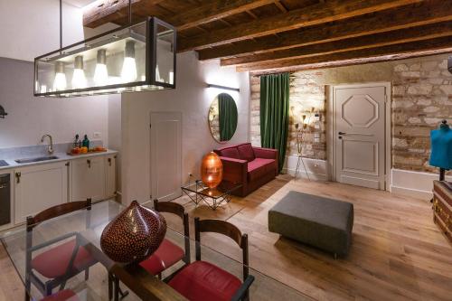 a living room with a red chair and a table at Residenza Palazzo Brenzoni in Verona