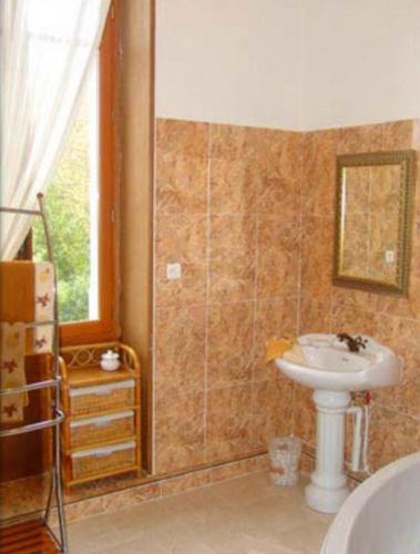 a bathroom with a sink and a toilet and a window at Château de la Court d'Aron in Saint-Cyr-en-Talmondais