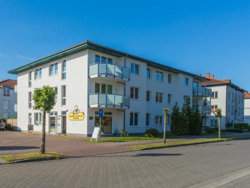 a white building on the side of a street at Am Maiglöckchenberg 19 in Ostseebad Karlshagen