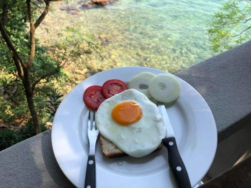 un plato con un huevo y pan en una mesa en Nice View Bungalow en Koh Chang