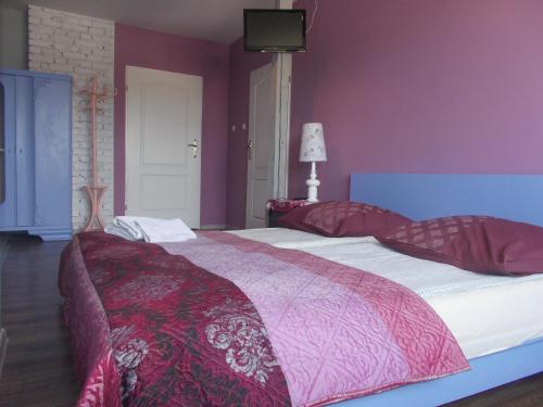 a bedroom with a large bed with purple walls at Bolimowianka in Bolimów