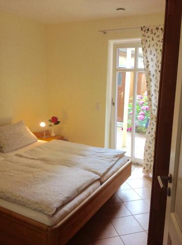 a bedroom with a bed and a sliding glass door at Haus Am Strom 50 in Warnemünde