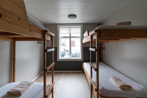 two bunk beds in a room with a window at Isafjordur Hostel in Ísafjörður