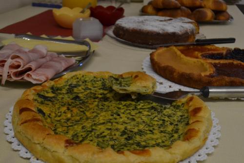 a table topped with pies and cakes on a table at Residence La Quiete in Alba