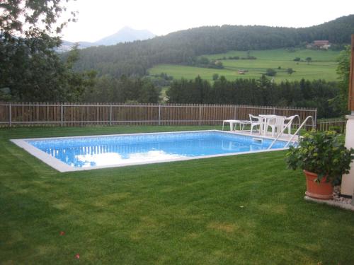een zwembad in een tuin met groen gras bij Panorama Residence Schlossblick in Rodengo