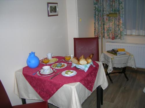 a table with plates of food and a teddy bear on it at Liry's Home in Tongeren
