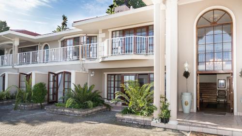 a large white house with balconies and plants at Moncrieff Manor in Knysna
