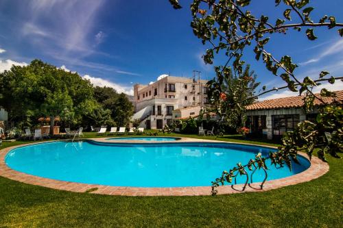 une grande piscine dans une cour avec un bâtiment en arrière-plan dans l'établissement Hotel Asturias, à Cafayate