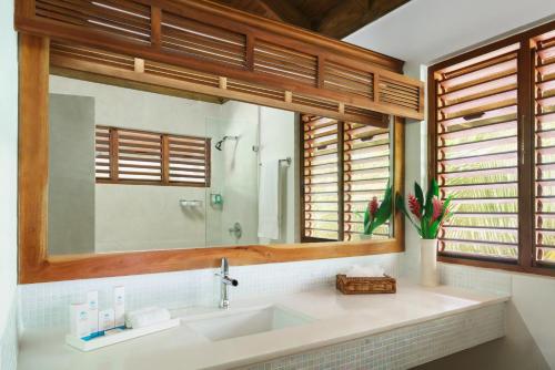 a bathroom with a sink and a mirror at Couples Swept Away in Negril