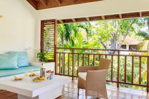 a room with a balcony with a table and chairs at Couples Swept Away in Negril