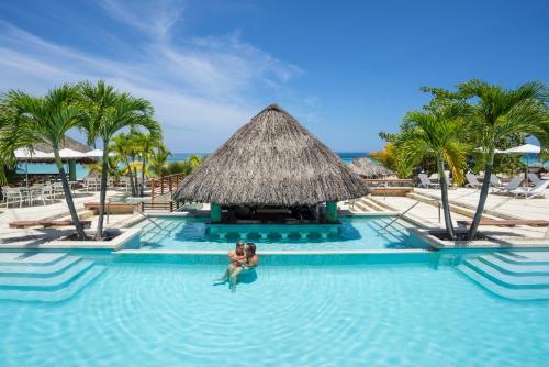 a couple in a swimming pool at a resort at Couples Swept Away in Negril