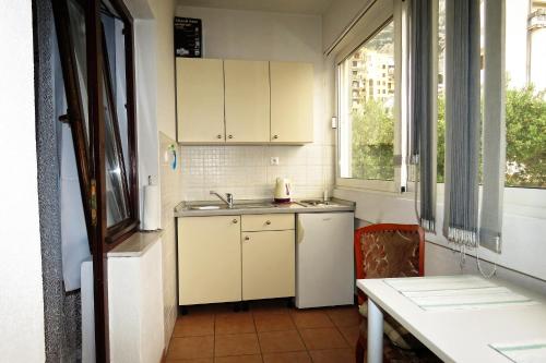 een keuken met witte kasten, een wastafel en een raam bij Apartments Milena & Ante in Makarska