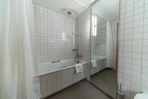 a bathroom with a shower, sink, and mirror at Hotel Isafjördur - Torg in Ísafjörður