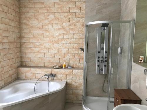 a bathroom with a bath tub and a shower at Balthasar Neumann Speiserei & Gästehaus - Zentrum Brühl -E-Ladestation, nähe Phantasialand in Brühl