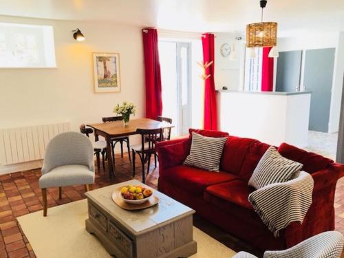 un salon avec un canapé rouge et une table dans l'établissement Manoir des Cognets, à Plurien