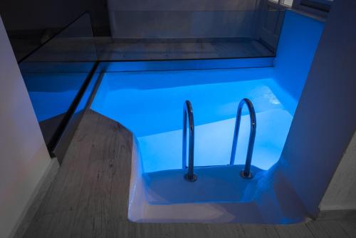 a blue bathtub with tongs in a room at Hyperion Oia Suites in Oia