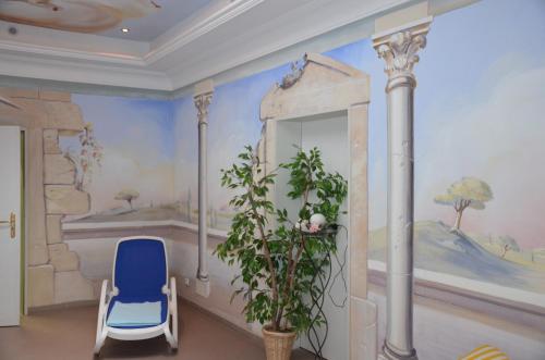 ガルミッシュ・パルテンキルヒェンにあるホテル ライニッシャー ホフの青い椅子と壁画が備わるお部屋