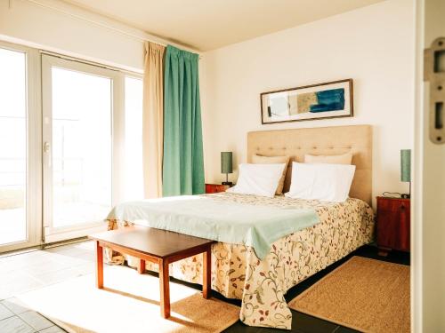 a hotel room with a bed and a table at Casa das Barcas in Lourinhã