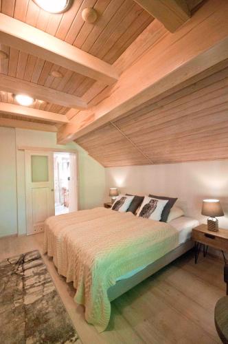 a bedroom with a large bed with a wooden ceiling at Górska Rezydencja in Karpacz