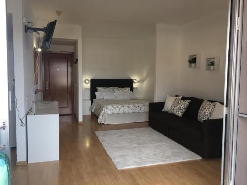 een woonkamer met een bed en een zwarte bank bij Estudio-Molino Blanco in Puerto de la Cruz