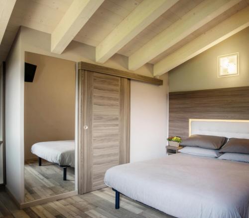 1 Schlafzimmer mit 2 Betten und Holzdecken in der Unterkunft Agriturismo Ruc del Lac in Boario Terme