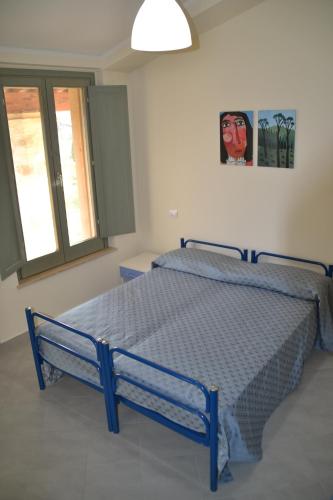 a blue bed in a room with a window at Fattoria Didattica Le Torte in Bettona