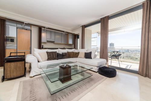 uma sala de estar com um sofá branco e uma mesa de vidro em Travel Hábitat L`Oceanogràfico em Valência