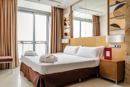 Exe Cunit Suites & Spa في كونيت: غرفة الفندق بسرير ومرآة