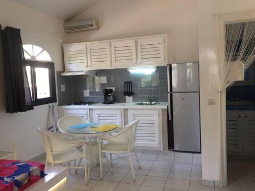 a kitchen with a table and chairs and a refrigerator at Studio Lipstick in Saly Portudal