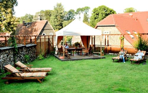 a group of people sitting in a yard with a tent at Landhotel Quirle-Häusl in Waltersdorf