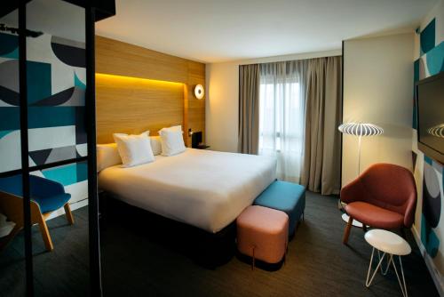a hotel room with a large bed and a chair at Hotel Mirador de Chamartín in Madrid