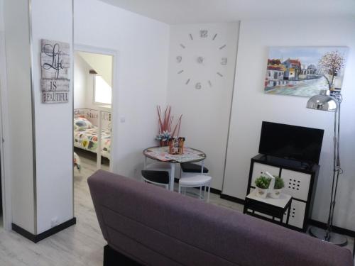 a living room with a couch and a table and a clock at Apartamento Cigüeña 1 in Zaragoza