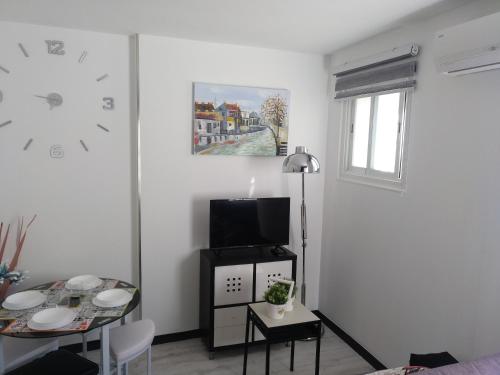 a living room with a table and a clock on the wall at Apartamento Cigüeña 1 in Zaragoza