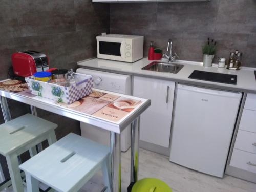 a small kitchen with a table and a microwave at Apartamento Cigüeña 1 in Zaragoza