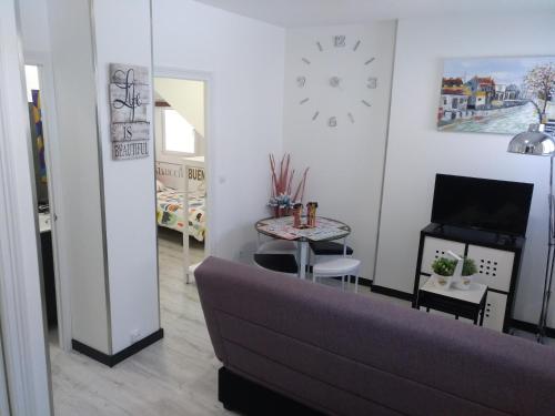 a living room with a couch and a clock on the wall at Apartamento Cigüeña 1 in Zaragoza