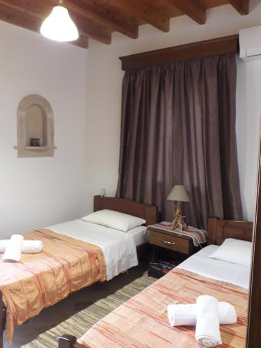 ein Hotelzimmer mit 2 Betten und einem Spiegel in der Unterkunft Villa Polymnia in Emborios