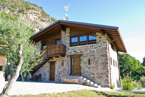 Casa de piedra con balcón en la parte superior. en Agriturismo Ruc del Lac, en Darfo Boario Terme