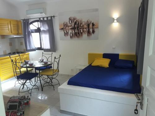 a bedroom with a bed and a table with chairs at Studio Samba in Saly Portudal