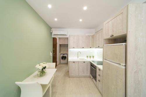 a kitchen with wooden cabinets and a vase of flowers at Feels like Home in Rethymno Town